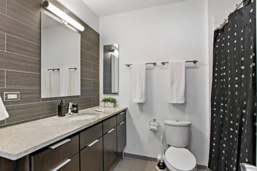 y baño con aseo, lavabo y espejo. en Serene & Contemporary Studio Apartment - Del Prado 817, en Chicago