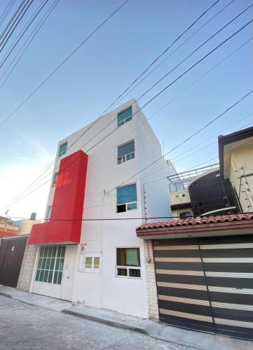 un bâtiment blanc et rouge avec garage dans l'établissement PEDRERA 39, à San Felipe Hueyotlipan