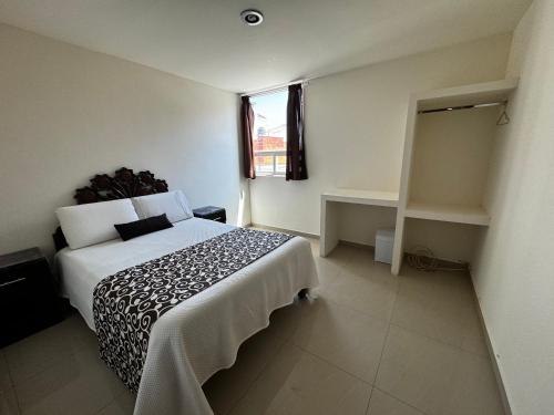 a bedroom with a bed and a window at PEDRERA 39 in San Felipe Hueyotlipan