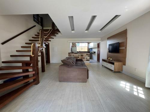 - un salon avec un canapé et un escalier dans l'établissement Casa encantadora a 100 m da praia de Geribá - WIFI 200MB - TV Smart - 5 Quartos - Garagem - Cozinha equipada - Churrasqueira, à Búzios