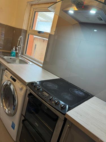 a kitchen with a stove top oven next to a sink at High street home in Eastleigh