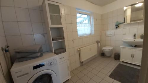 ein Badezimmer mit einer Waschmaschine und einem Waschbecken in der Unterkunft Melen in Rust