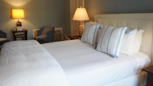a bedroom with a large white bed with blue pillows at Copper Beech Inn in Ivoryton