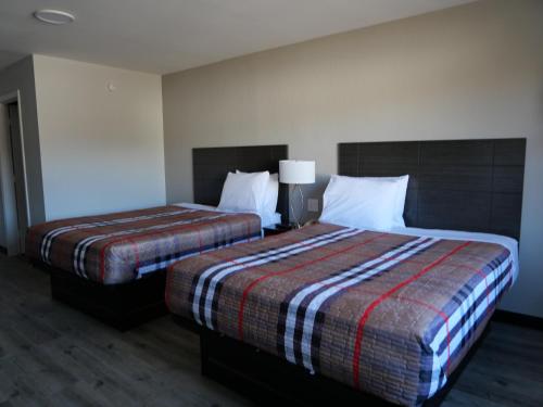 a hotel room with two beds and a lamp at Hilltop Express Inn in Groton