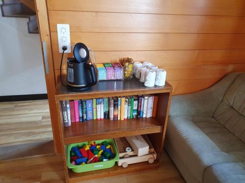 a book shelf filled with books next to a couch at Hotel Garni Alpenruh in Lenk
