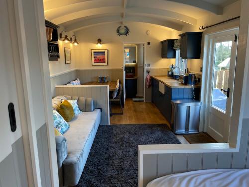 a living room with a couch and a kitchen at The Grove Glamping in Cromer