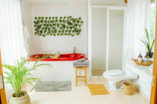 baño con bañera roja y aseo en Casa Zazen en Amatlán