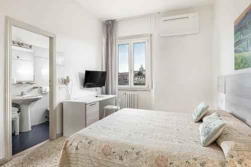 a white bedroom with a bed and a sink at Hotel Minerva in Siena