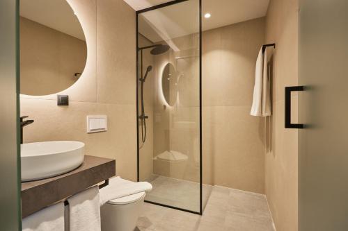 a bathroom with a glass shower and a sink at Bizarre Boutique Hotel in Varna City