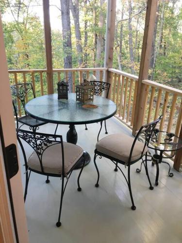a porch with a table and chairs on a deck at Historic Farmhouse by Nature Preserve in Charleston