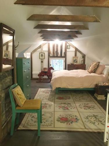 a bedroom with a bed and a chair in a room at Historic Farmhouse by Nature Preserve in Charleston