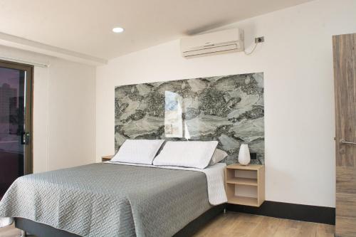 una camera con letto e murale di DUSANO BOUTIQUE HOTEL a Santa Marta