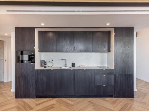 a kitchen with dark wood cabinets and a sink at Luxury Alhambra Penthouse Collection Gran Via in Granada