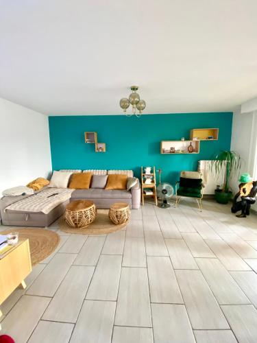 - un salon avec un canapé et un mur bleu dans l'établissement Le paisible, à Décines-Charpieu