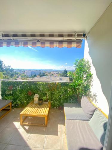 d'une terrasse avec une table et un canapé. dans l'établissement Le paisible, à Décines-Charpieu