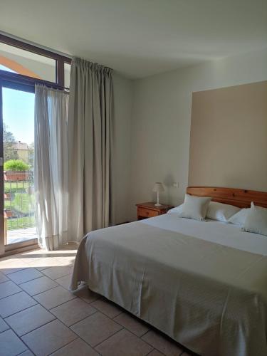 a bedroom with a bed and a large window at Agriturismo La Vigna in Colà di Lazise