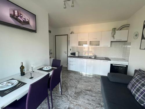 a kitchen and living room with a table and chairs at Guesthouse Villa Stanger 2 in Lovran