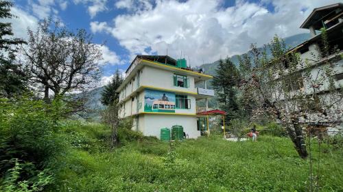 a building on a hill in a field at Safar Hostel Manali in Manāli