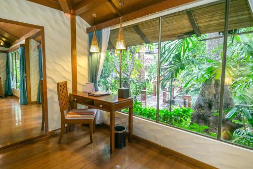 an office with a desk and a large window at Centara Koh Chang Tropicana Resort in Ko Chang