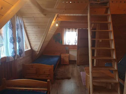 a small room with a bunk bed and a ladder at Szałas tatrzański in Kościelisko