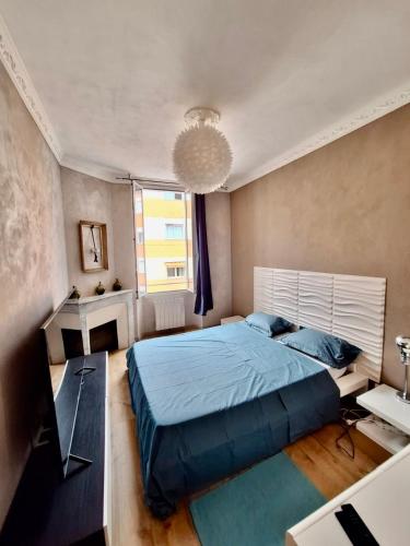 - une chambre avec un grand lit bleu et un lustre dans l'établissement T3 moderne et climatisé - Plages à pied - PARKING GRATUIT, à Vallauris