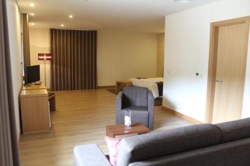 a living room with a couch and a room with a bed at Douro Cister Hotel Resort in Ucanha