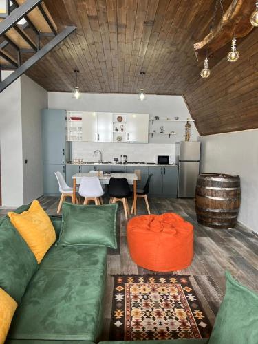 a living room with a couch and a kitchen at Deka Achkhoti in Stepantsminda