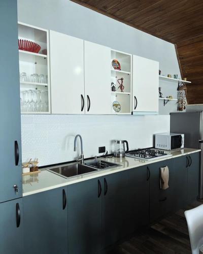 a kitchen with white cabinets and a sink at Deka Achkhoti in Stepantsminda