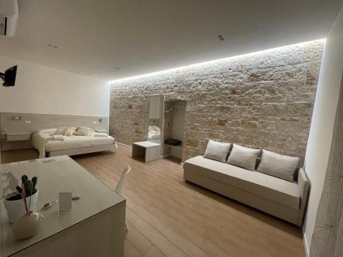 a living room with a couch and a brick wall at Casa Mariù in Turi