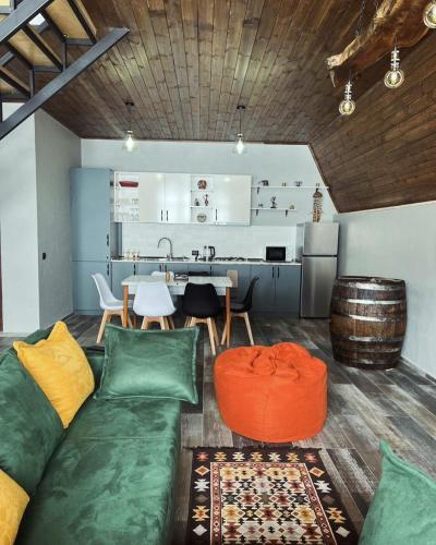 a living room with a couch and a kitchen at Deka Achkhoti in Stepantsminda
