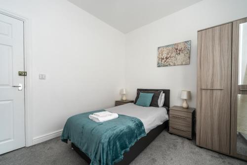 - une chambre avec un lit et une armoire en bois dans l'établissement Cosy 2BR Apartment with Free Street Parking, à Frodingham