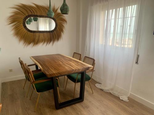 a dining room table with chairs and a mirror at Midway Apartamento in Torremolinos