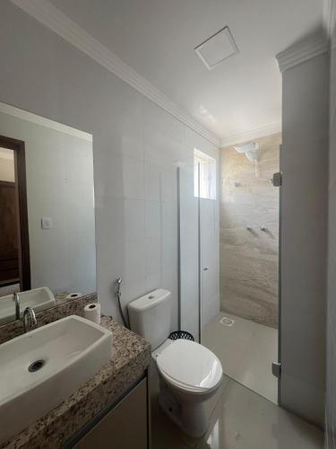 ein Bad mit einem WC, einem Waschbecken und einer Dusche in der Unterkunft Apartamento Completo - Algarve 203 e 204 in Patos de Minas