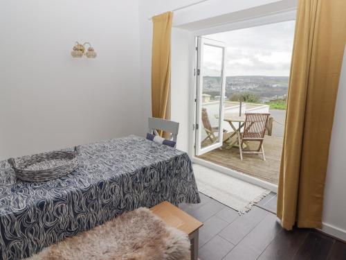 a bedroom with a bed and a door to a patio at Harbour Village Views in Goodwick