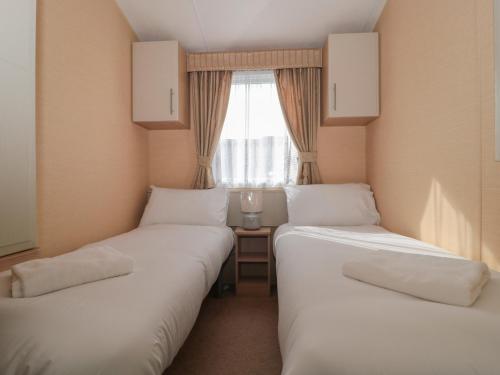 two twin beds in a room with a window at Bayview 23 in Taunton