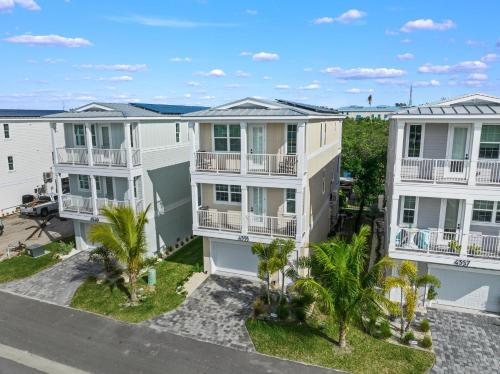 an aerial view of three apartment buildings with palm trees at Shore To Escape at Hunter's Point in Cortez
