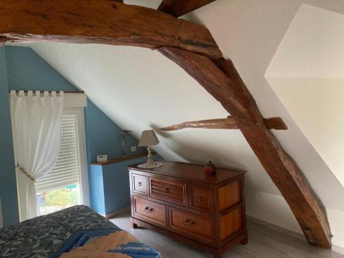 une chambre avec un lit et une commode en bois dans l'établissement Maison les palmiers, à La Bohalle