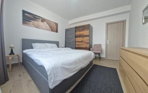 um quarto com uma cama grande e uma cómoda em X rent apartment em Prim Decembrie