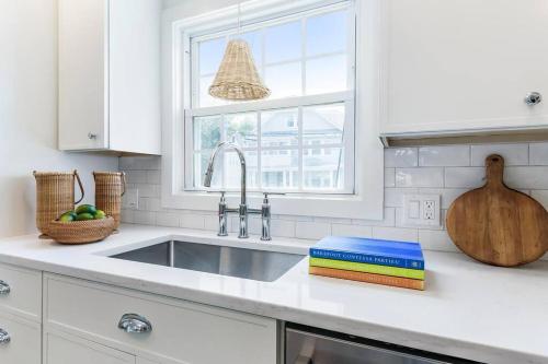 a white kitchen with a sink and a window at Charming Beachside Home in Bridgeport