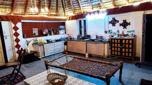 a kitchen with a bench in the middle of a room at Shivoham the earthen Home in Dehradun