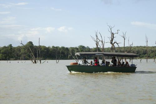 a group of people on a boat in the water at Waterwoods Lodge Kabini in Begūr