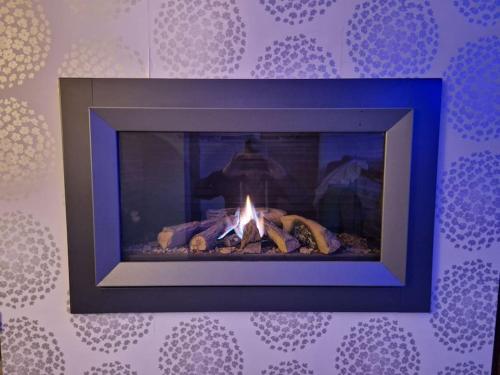 a fireplace with a fire in it in a room at Cribden Hill View in Rawtenstall