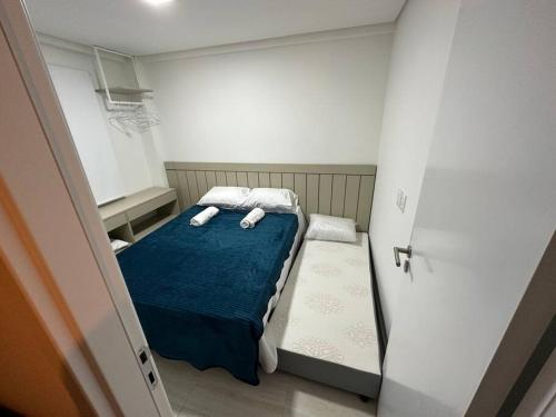 Flat Beira Mar Porto de Galinhas - Pé na areia في بورتو دي غالينهاس: غرفة صغيرة عليها سرير وفوط