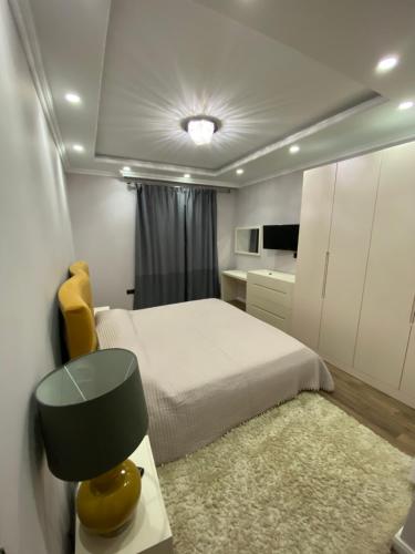 1 dormitorio con 1 cama y 1 mesa con silla amarilla en Apartament Tirana, en Tirana
