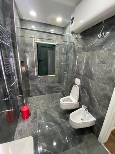 y baño con aseo y lavamanos. en Apartament Tirana, en Tirana
