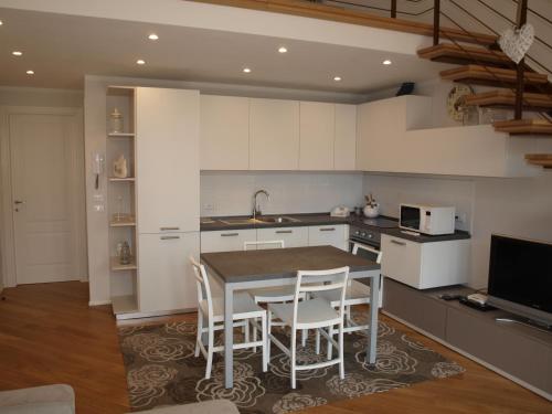 a kitchen with a table and chairs and a microwave at Il Pontile Holidays Apartment in Marina di Pietrasanta