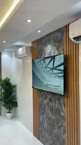 a television hanging on a wall in a room at درة الشرق للشقق المخدومة in Al Madinah