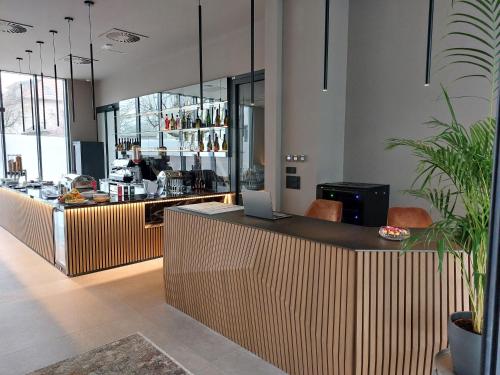 a restaurant with a bar with a laptop on a counter at Tivoli Boutique Inn in Ljubljana