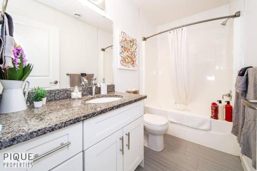 a white bathroom with a sink and a toilet at *Vibrant Suite* Long Stays - Wi-Fi - Fireplace - NFLX in Edmonton