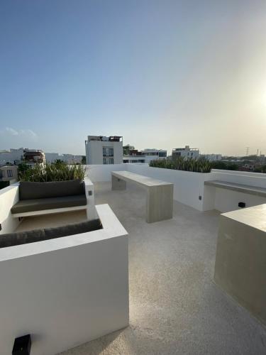 a white building with benches on the roof at Coco Live Suites in Playa del Carmen